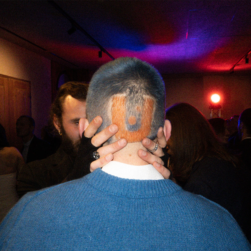 Ragazzo con capelli dipinti a U in arancione e blu
