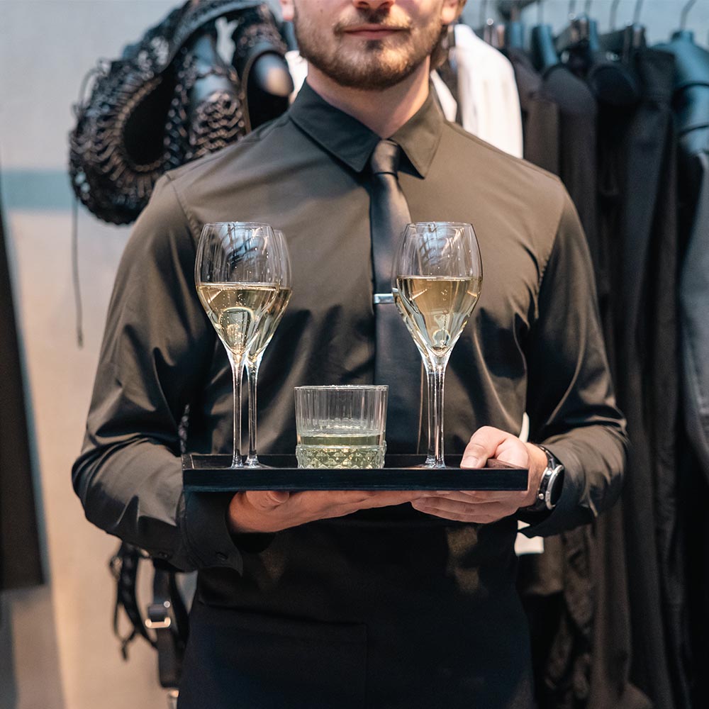 Cameriere con vassoio di calici e drink