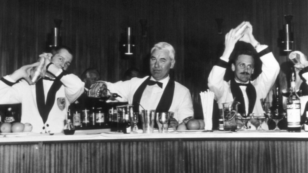 Barman che preparano cocktail al bancone in bianco e nero