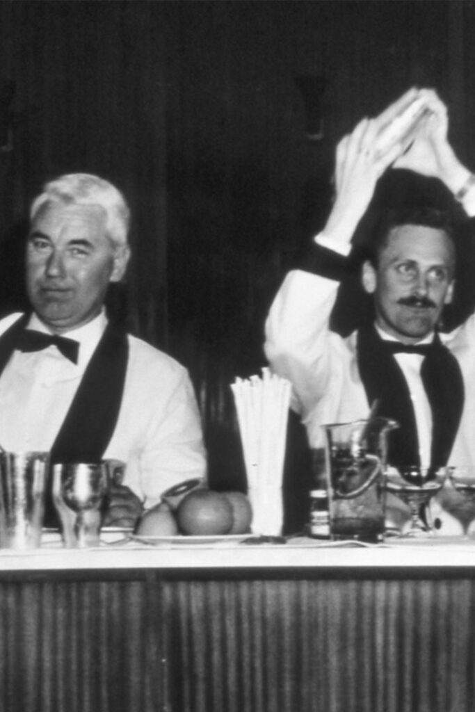 Camerieri in abito anni 60 dietro a un bancone