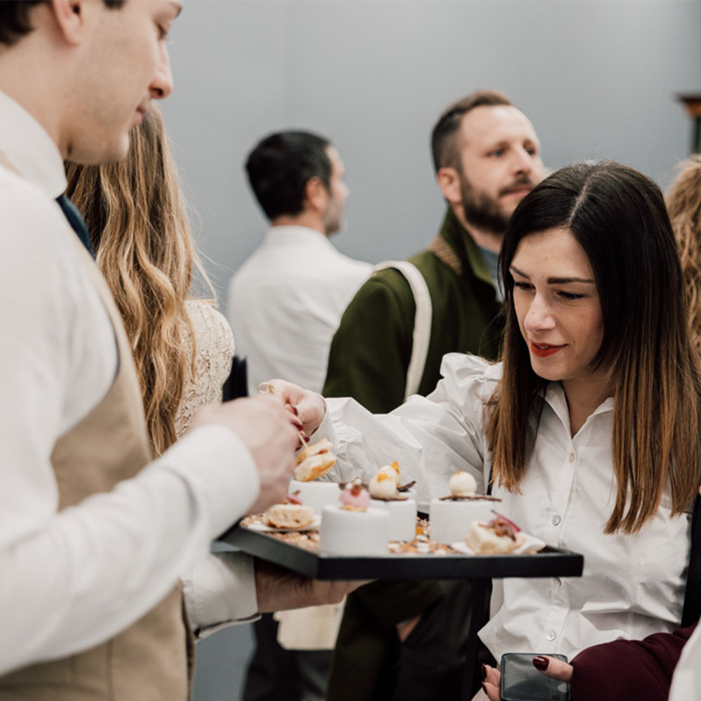 Ospite che prende un finger food dal vassoio del cameriere