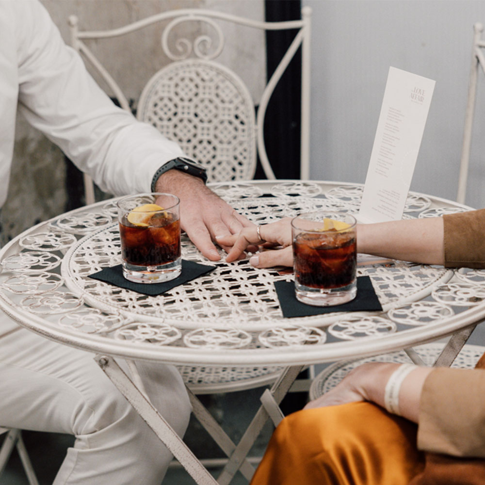 Mani che si toccano su un tavolo con cocktails