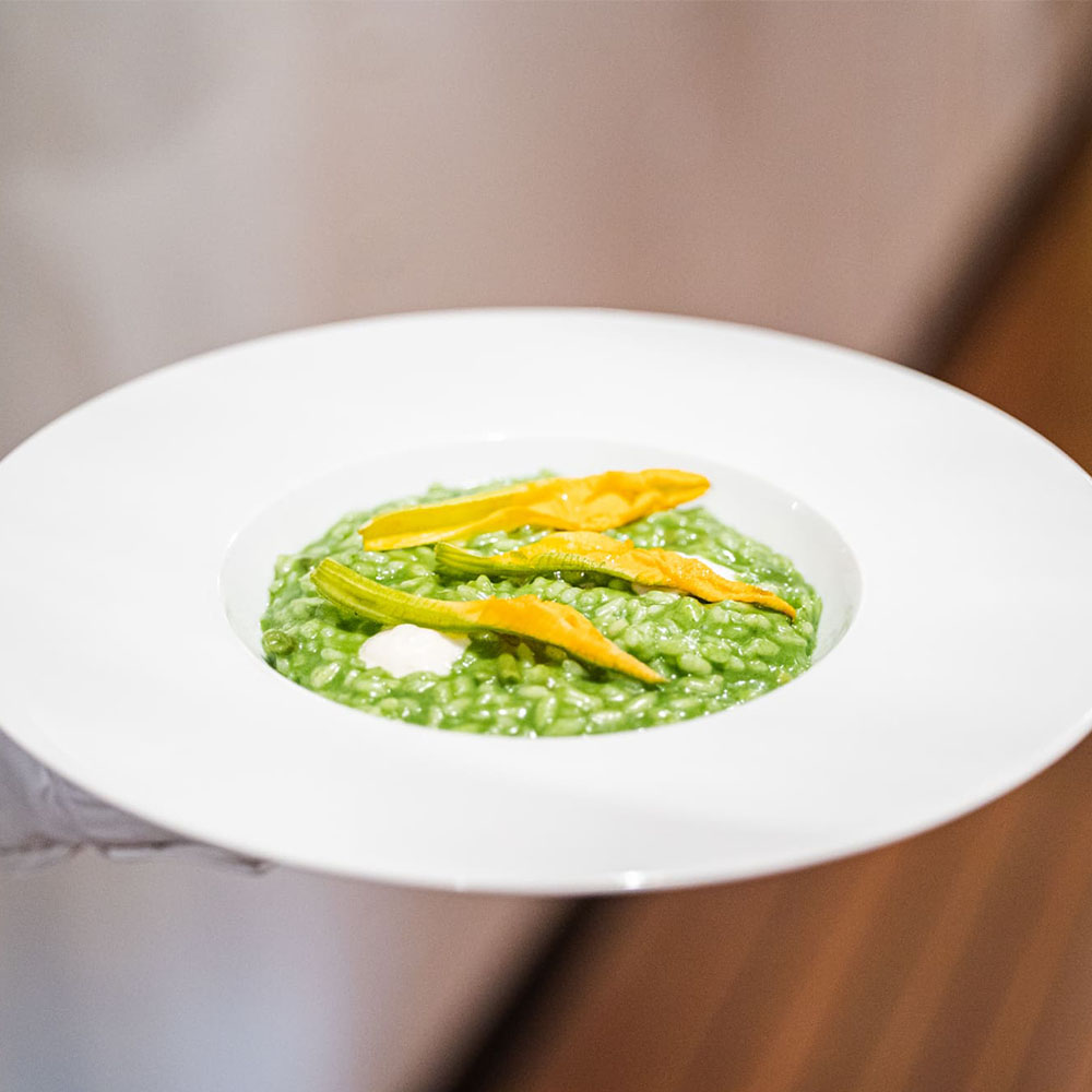 Piatto di risotto verde con fiori di zucca