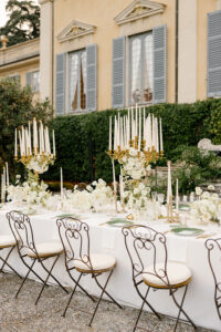 Tavola preparata di fronte alla villa con candelabri bianchi e oro