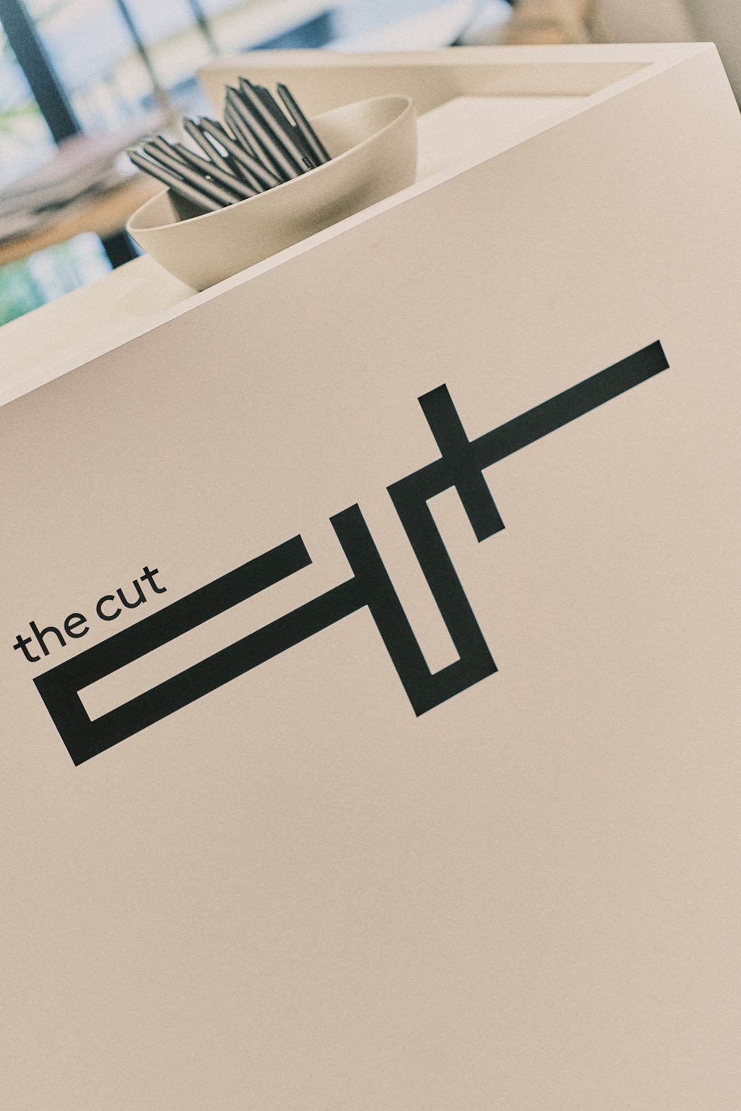 insegna the cut nera su bancone bianco