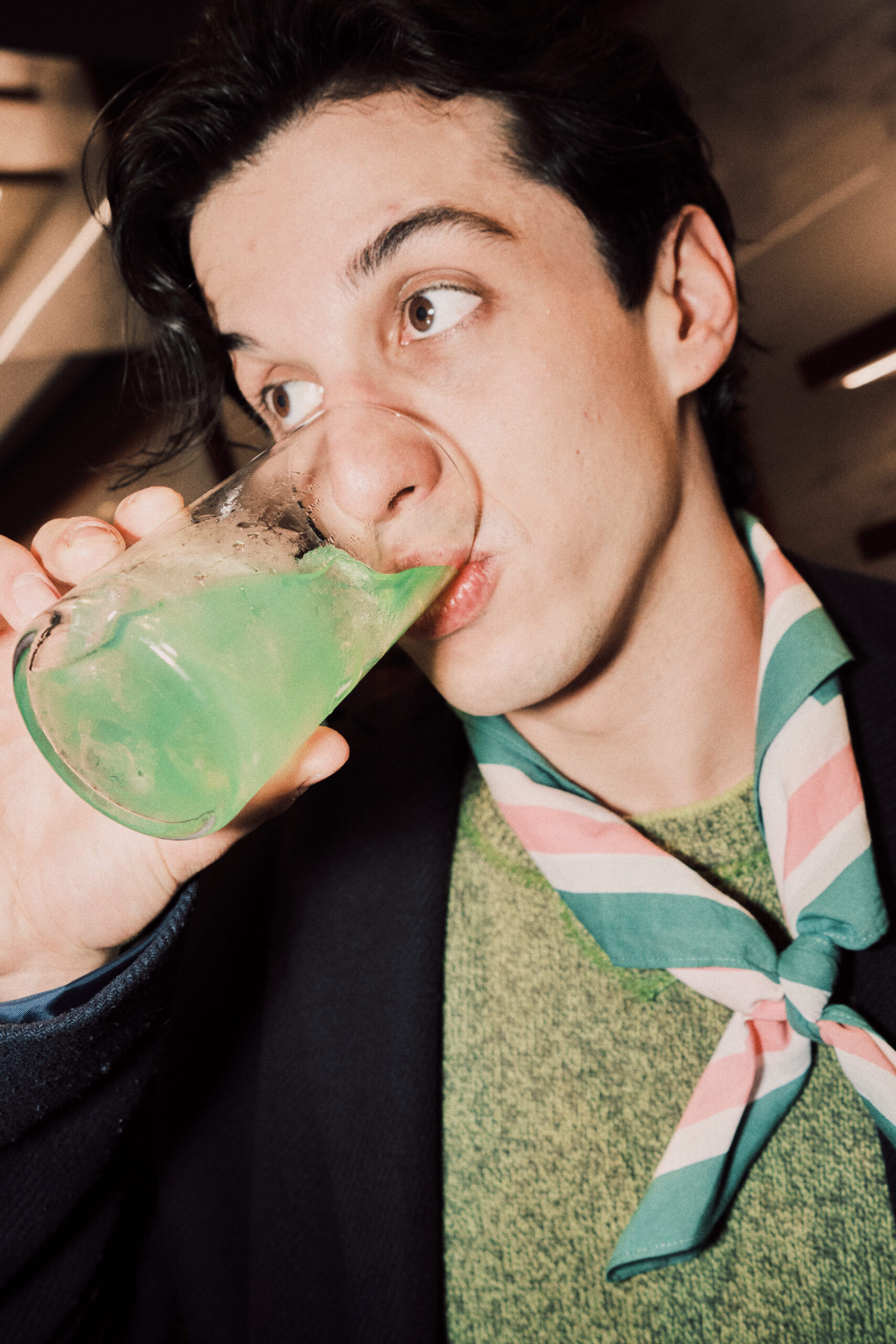 Ragazzo che beve un drink verde
