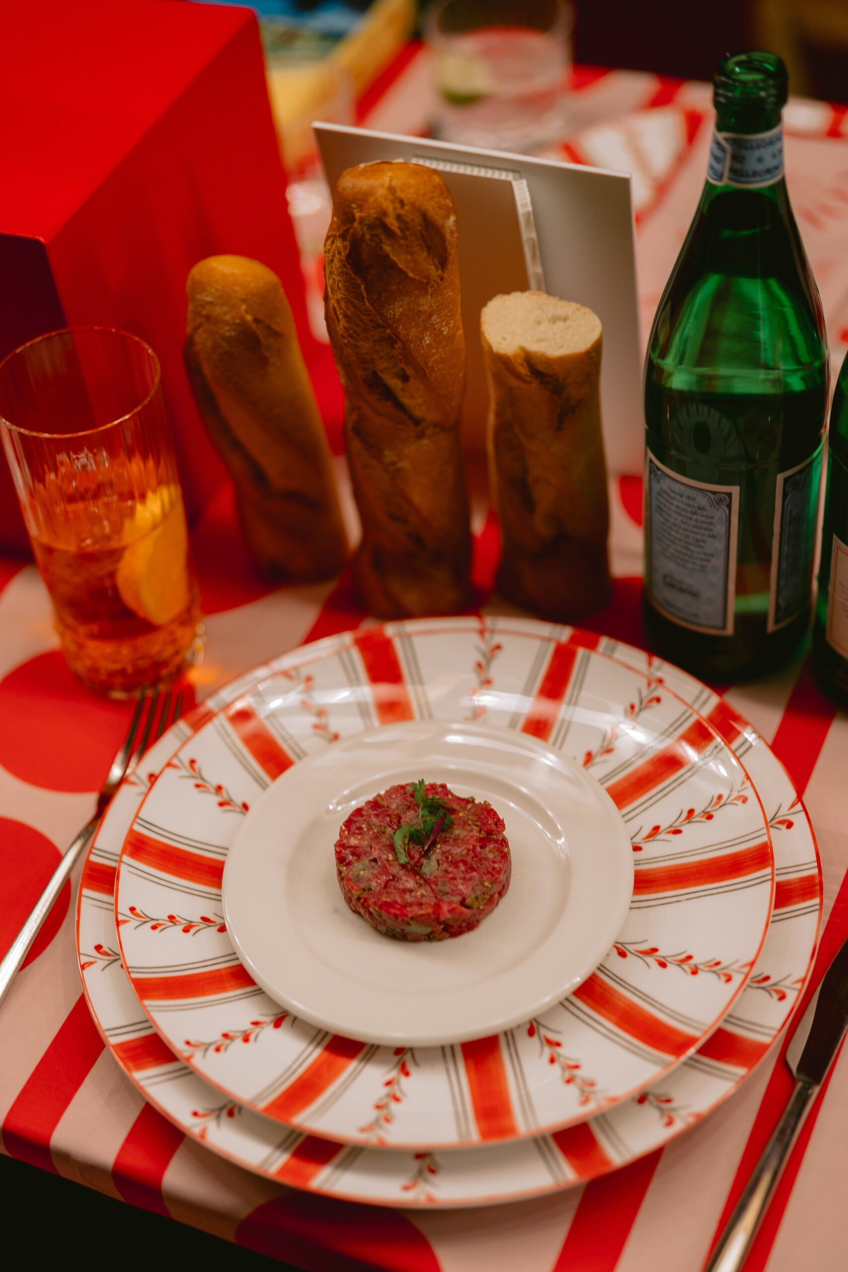Tartare di manzo impiattata su piatti bianco e rossi