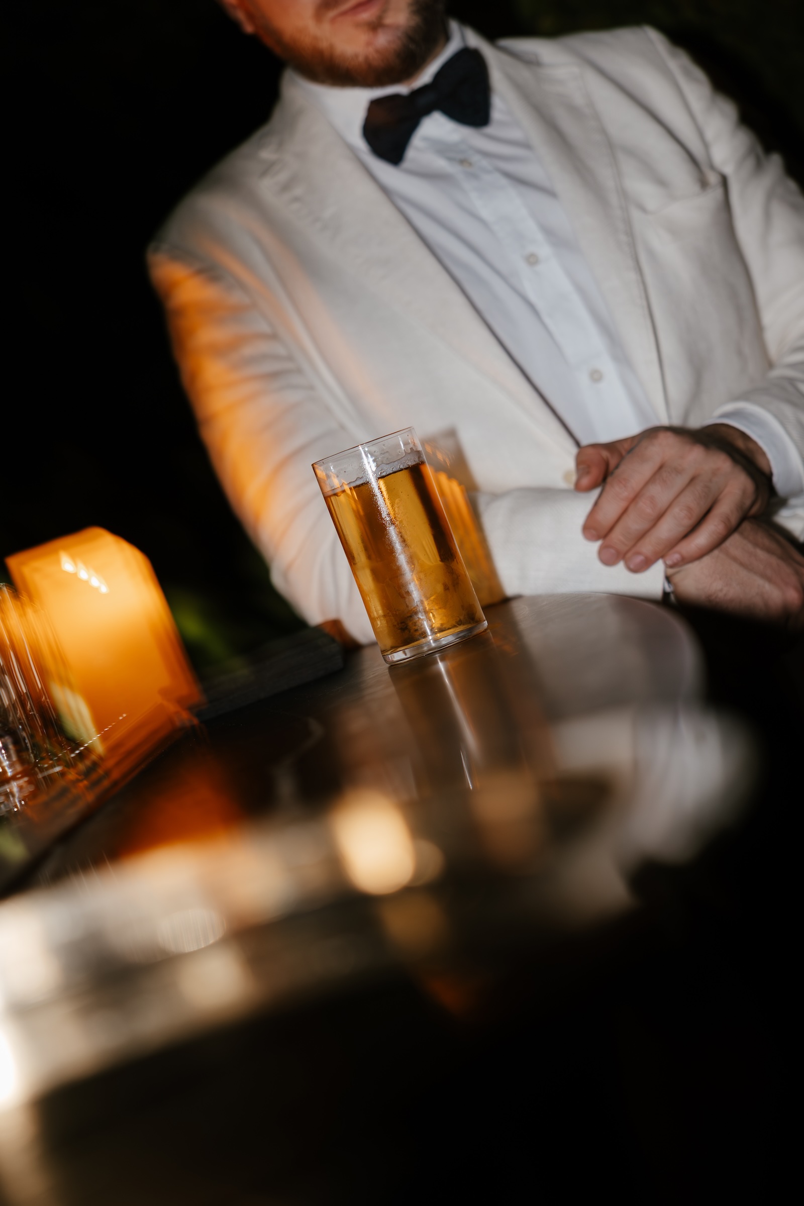 Ospite appoggiato al bancone con drink